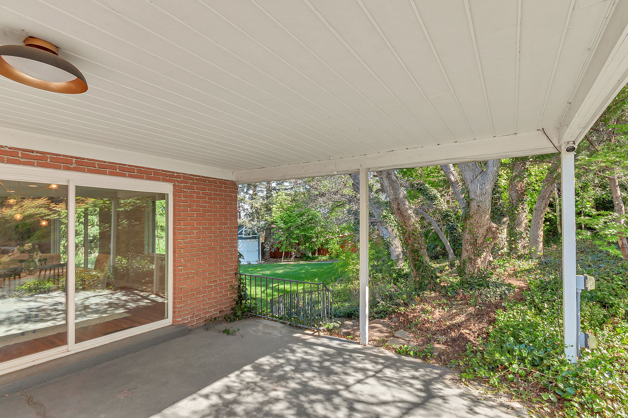 Covered patio featuring concrete flooring and a modern ceiling light fixture