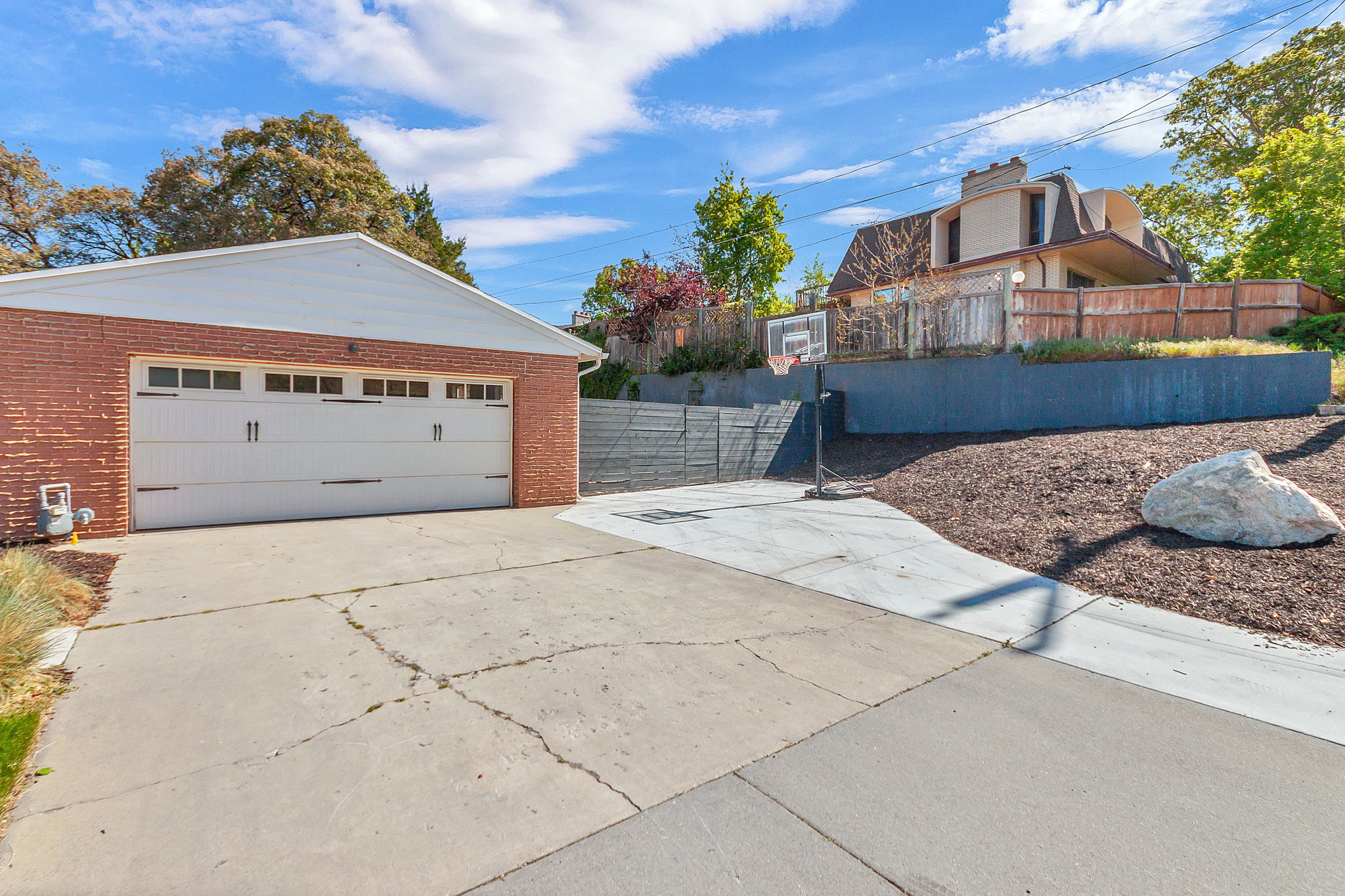Brick-clad garage with a white overhead door and transom-style windows