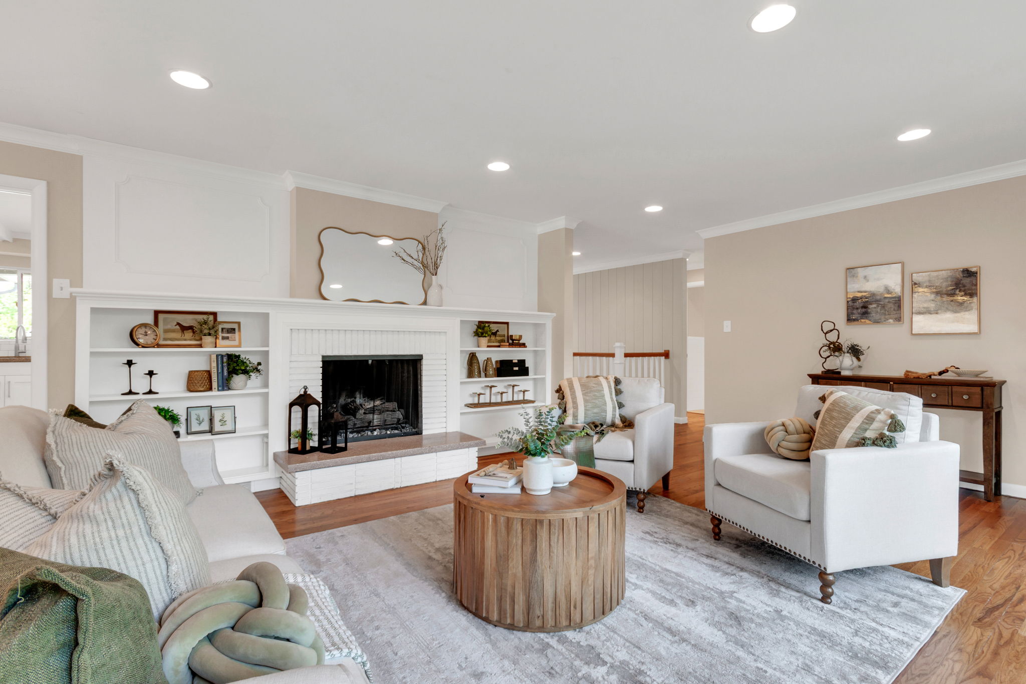 Living area featuring a white brick fireplace with a raised hearth, flanked by built-in shelving