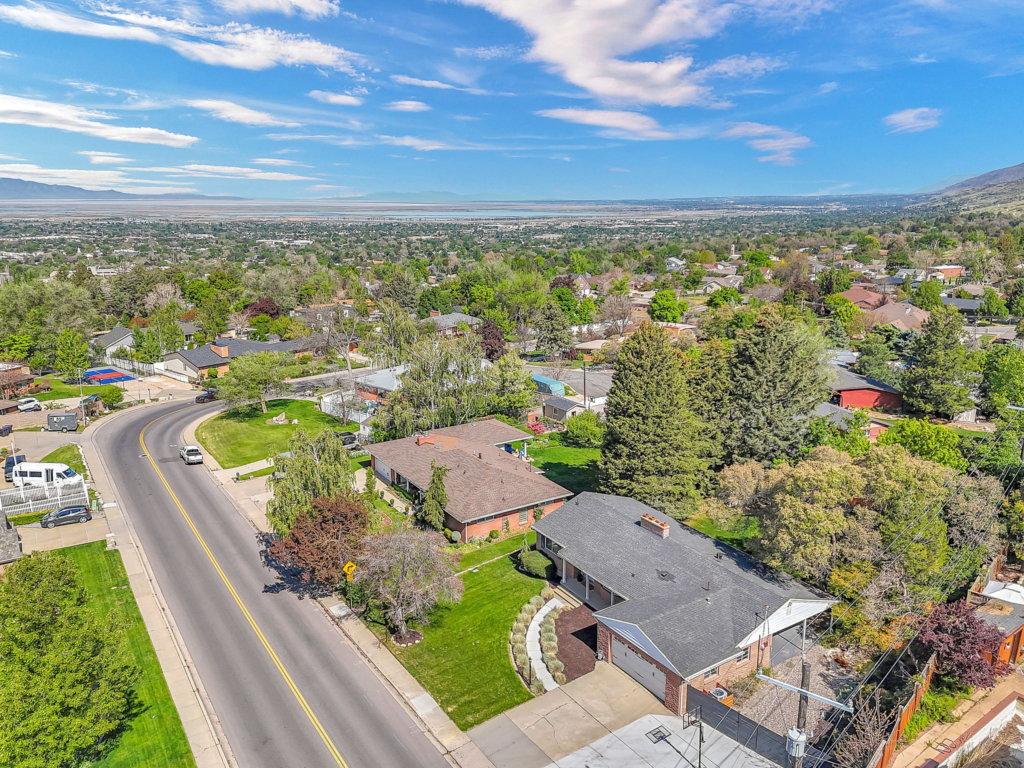 Aerial perspective showcasing a residential neighborhood with a distant body of water and mountain range