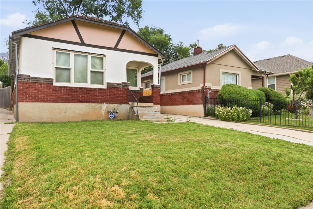 Traditional-style home featuring a red brick lower facade and white upper siding with decorative dark trim