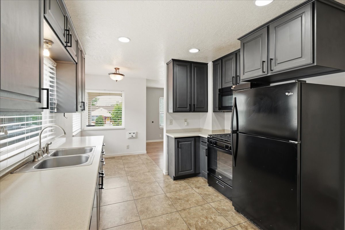 Kitchen featuring dark cabinetry, light countertops, and tile flooring