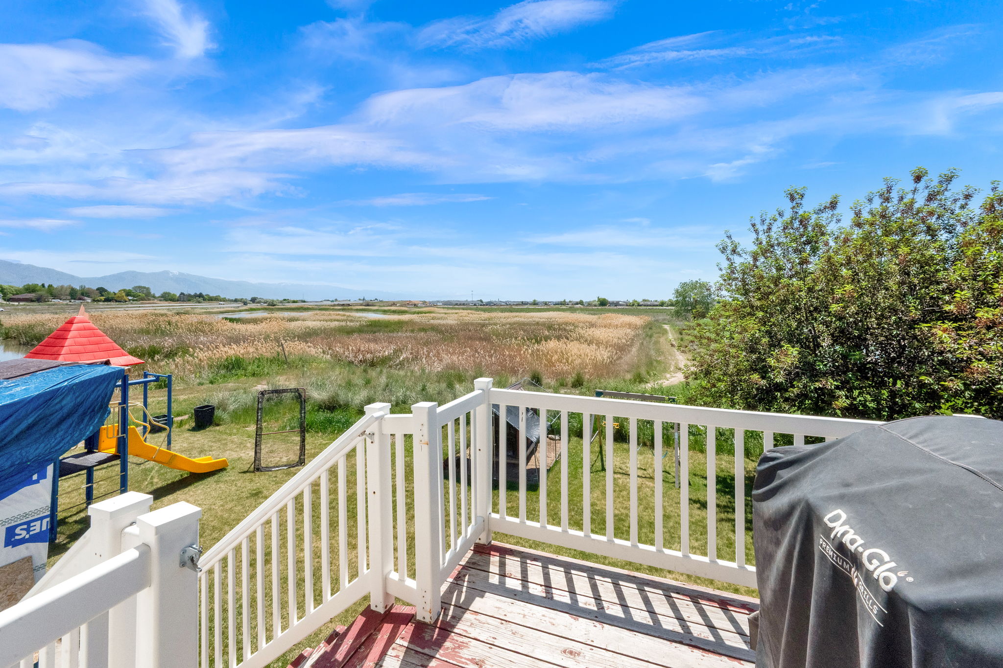 Expansive outdoor deck with white railings and a natural wood-finish floor