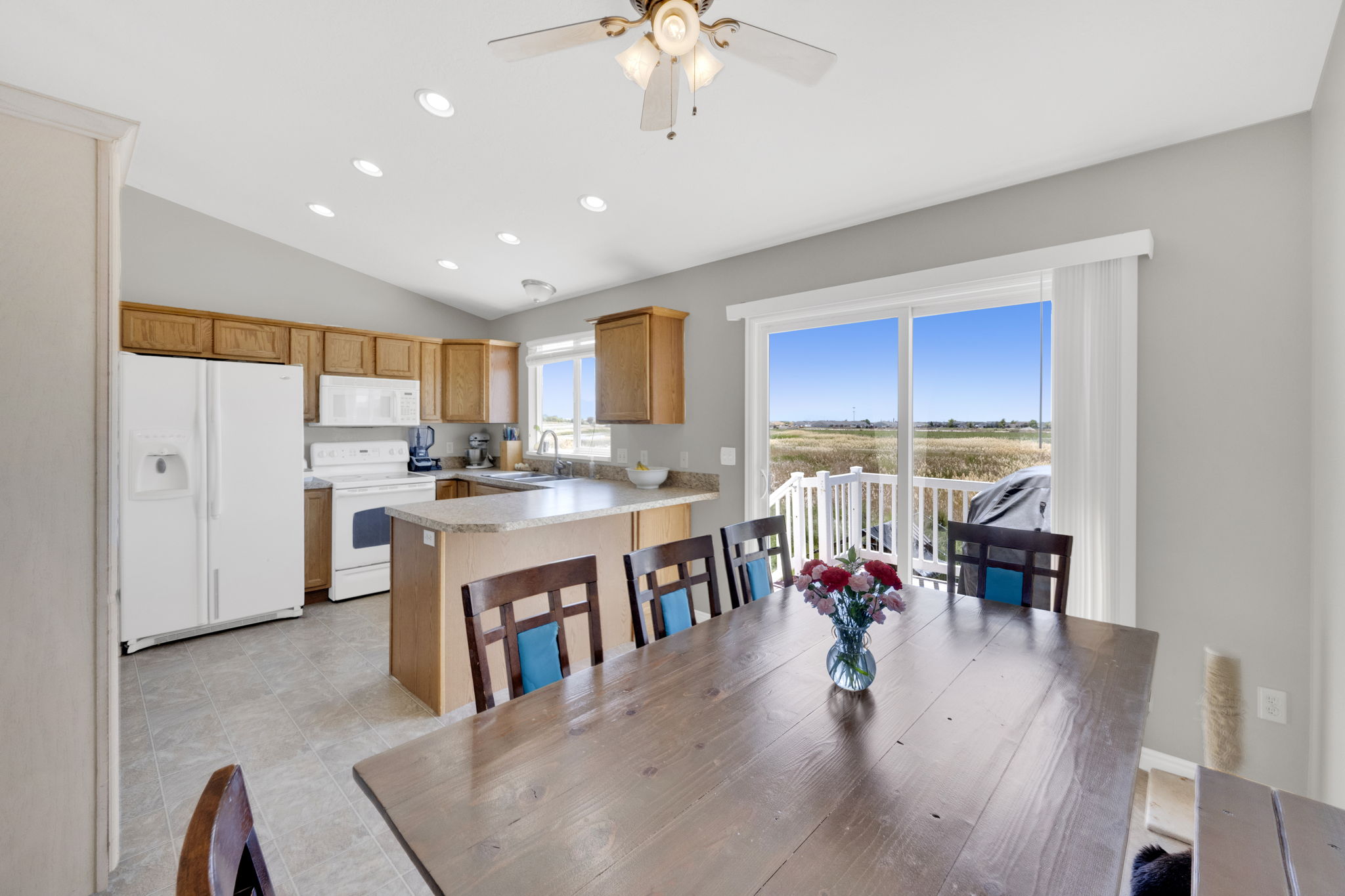 Open-concept kitchen and dining area featuring a vaulted ceiling with recessed lighting and a ceiling fan