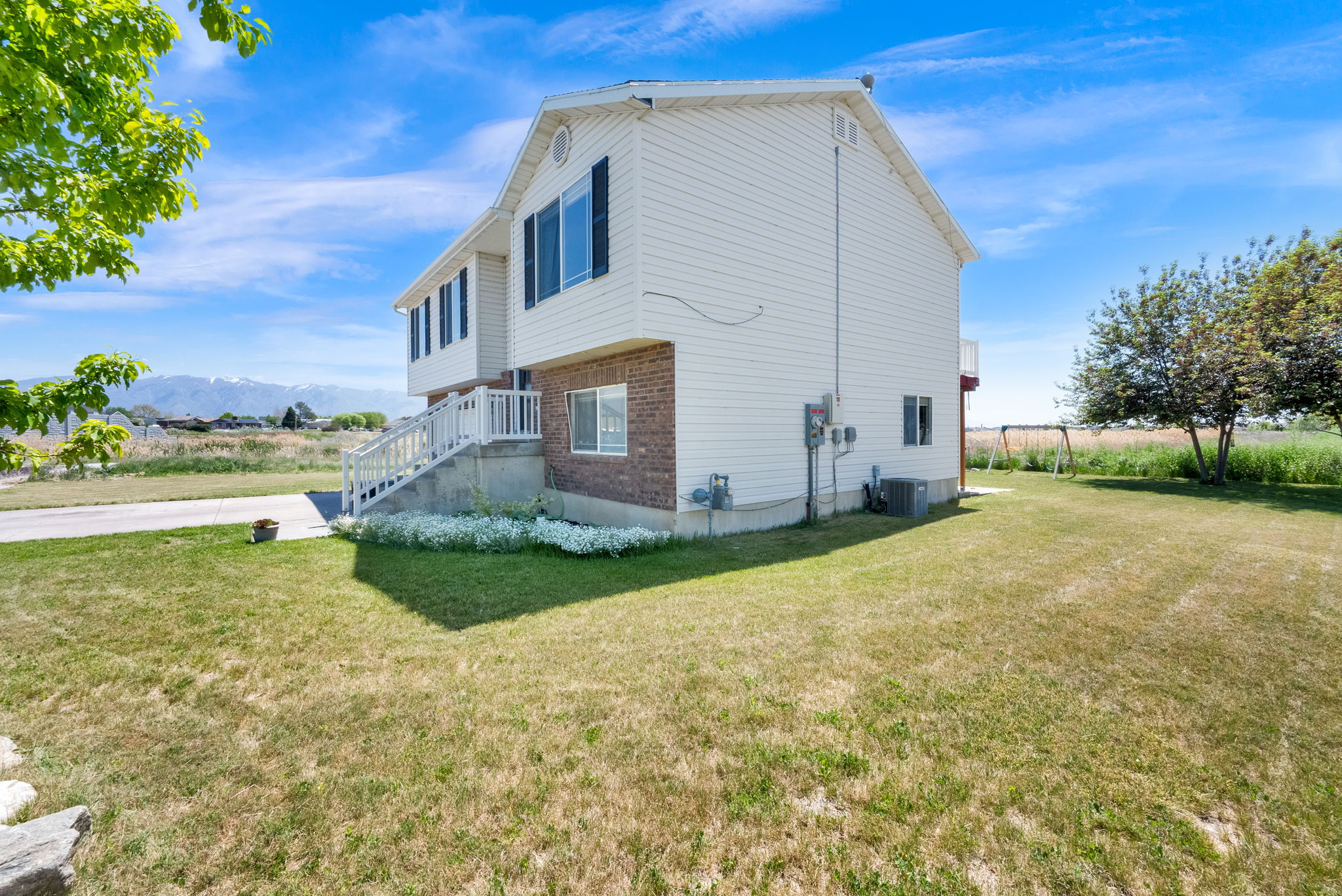 White siding exterior with brick accents