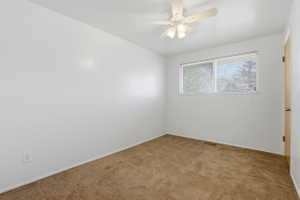Carpeted room featuring a white ceiling fan with integrated lighting, a window with horizontal blinds, and neutral painted walls
