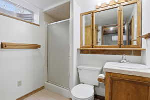 Bathroom featuring a corner vanity with a built-in sink, wood-finish cabinetry, and a mirrored medicine cabinet