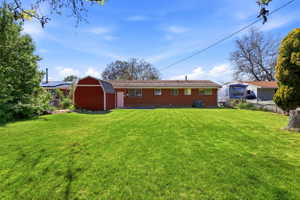 Expansive green lawn with a red barn-style shed, providing ample outdoor space