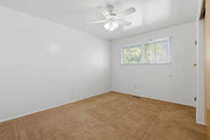 Carpeted room with a ceiling fan light fixture, a window with horizontal blinds, and white painted walls