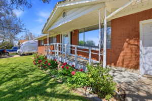 Brick exterior with covered front porch and entry ramp access