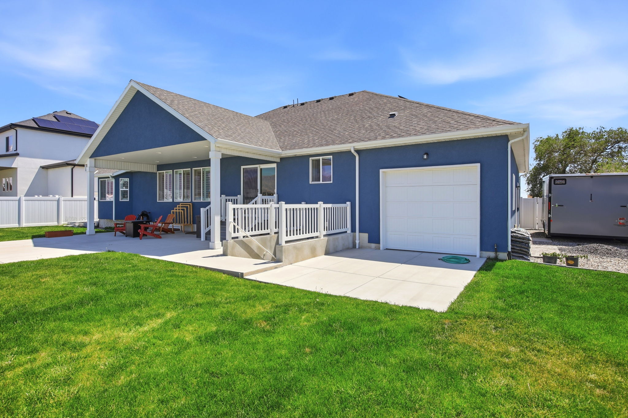 Exterior featuring blue siding, a covered patio, and a two-car garage