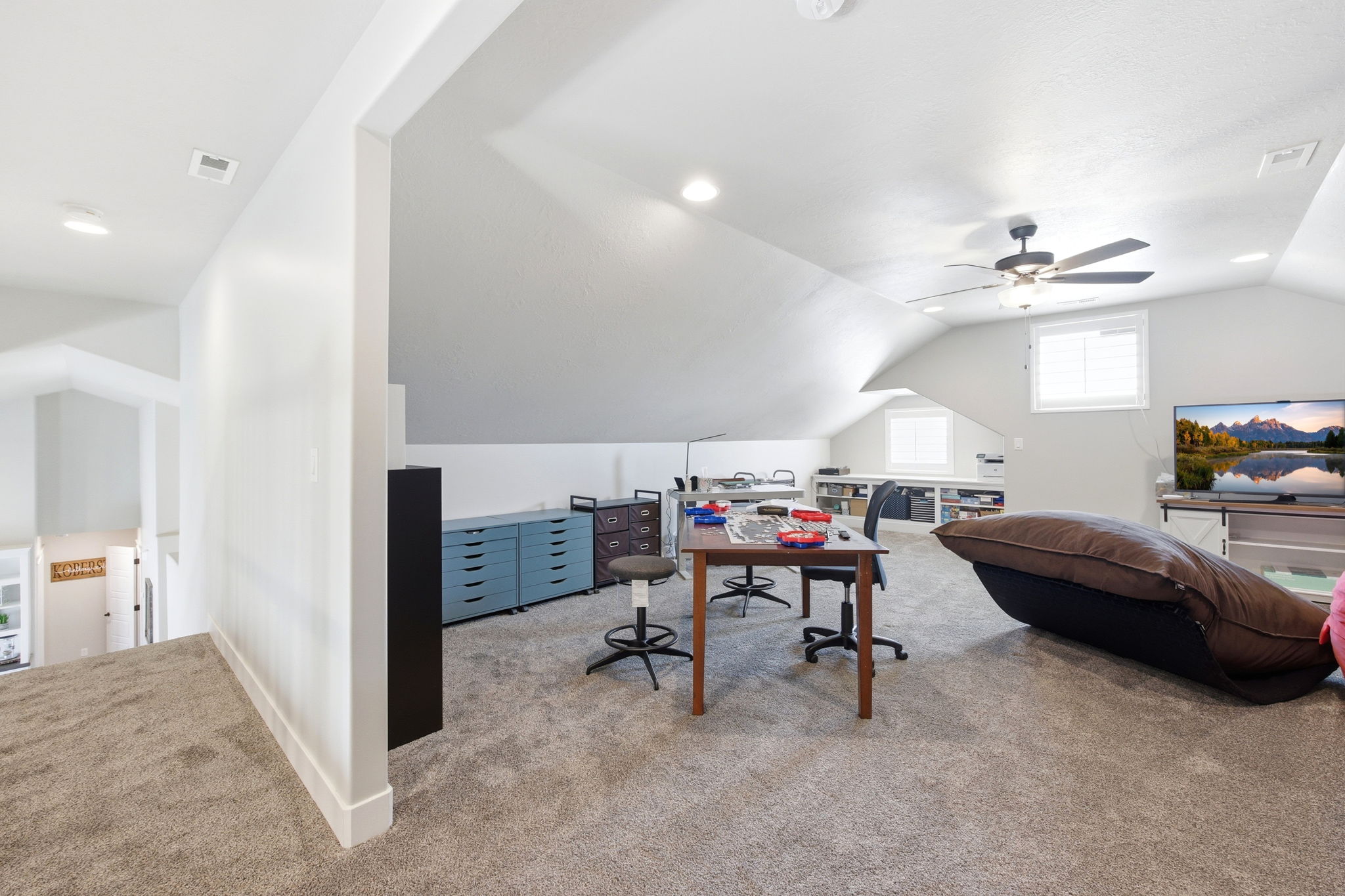 Spacious carpeted bonus room with sloped ceilings and recessed lighting