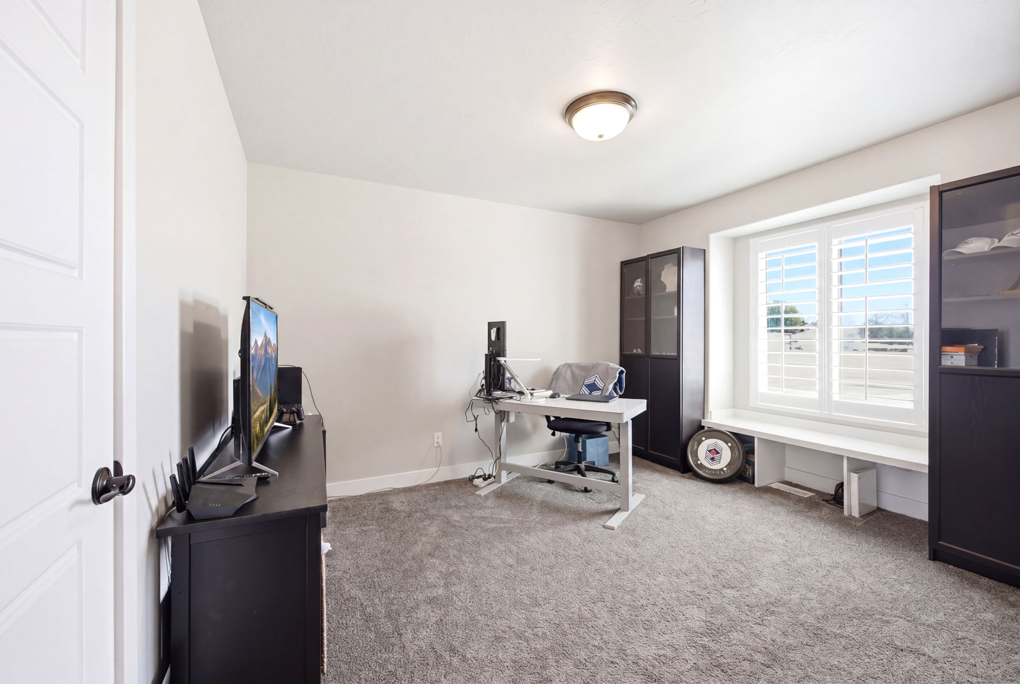 Spacious room featuring neutral-toned walls and grey carpet flooring