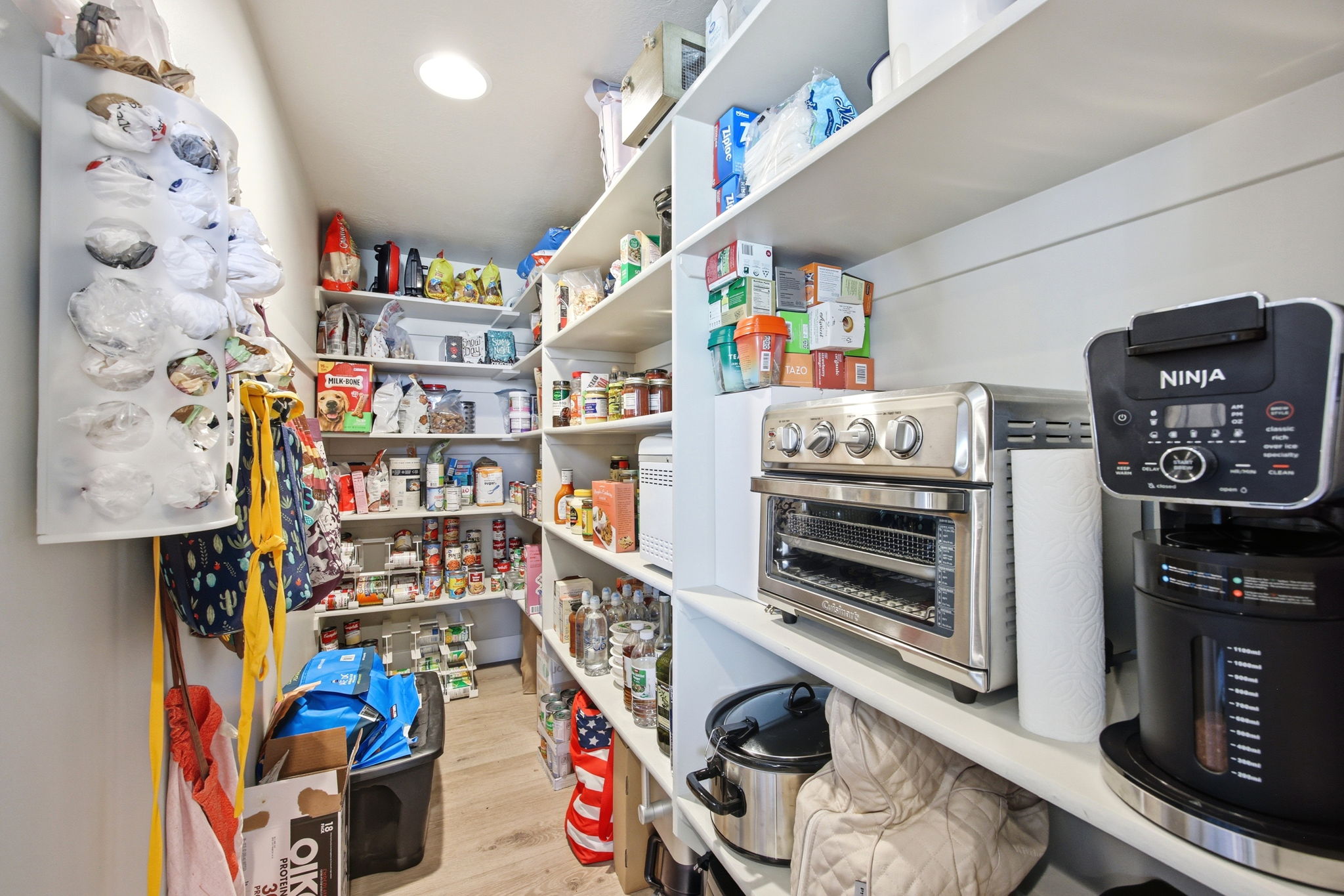 Walk-in pantry featuring extensive white shelving