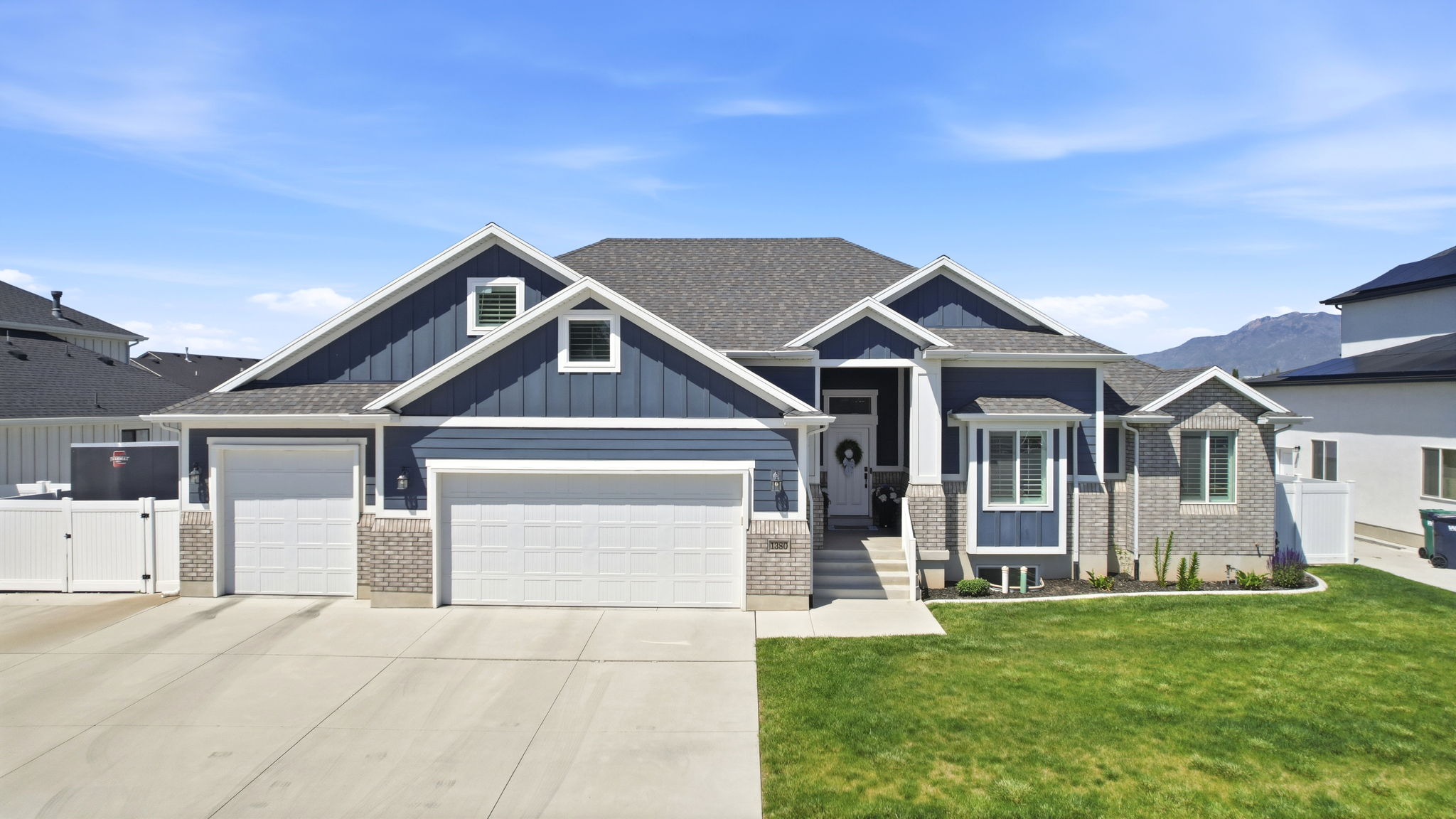 Contemporary residence featuring a two-car garage, an additional single-car garage, and a concrete driveway