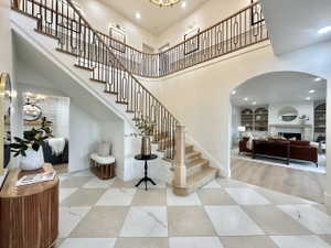 Grand two-story entryway featuring a curved staircase with wrought iron balusters and hardwood treads