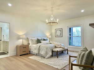 Bedroom featuring wood-finish flooring, recessed lighting, and a chandelier with a circular wood-look frame