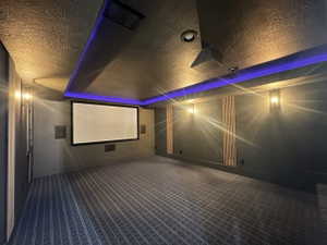 Dedicated media room featuring a large projection screen, built-in speakers, and recessed ceiling lighting