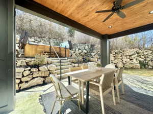 Covered patio featuring a natural wood plank ceiling with recessed lighting and a ceiling fan