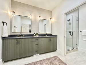 Dual vanity with olive green fluted cabinetry and dark countertops