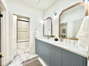 Dual vanity with light blue fluted cabinetry and white countertops