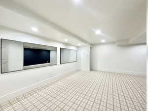 Spacious room featuring patterned carpeting, recessed lighting, and a white color palette