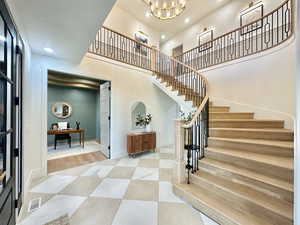Grand entryway featuring a curved staircase with natural wood treads and black metal balusters