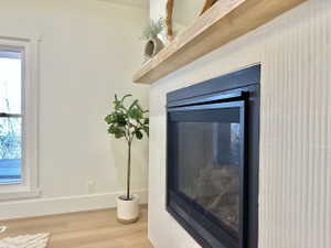 Built-in fireplace with a black surround and glass screen, complemented by a light wood mantel