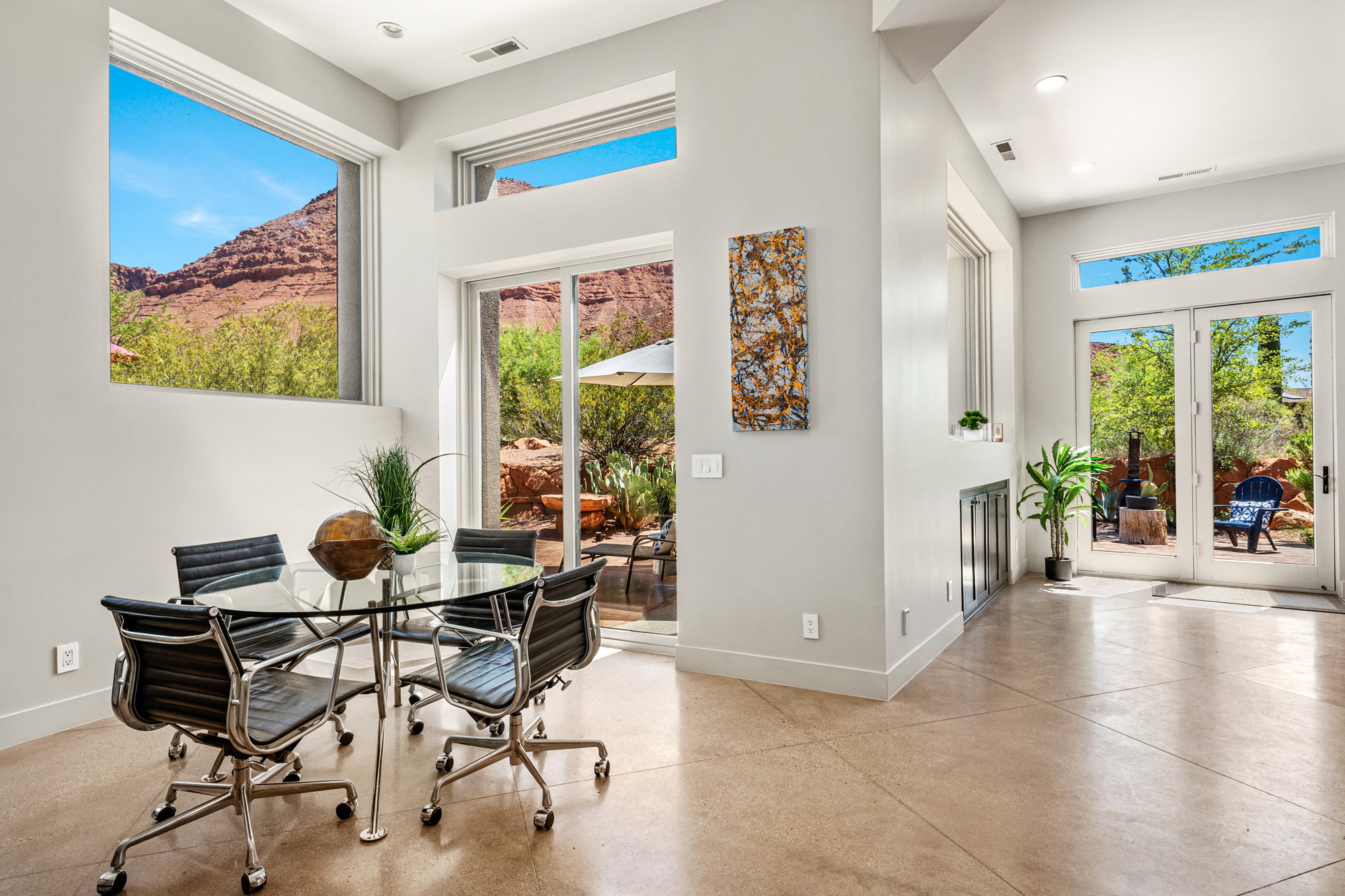 Open concept living area featuring expansive windows, glass sliding doors, and glass paneled double doors