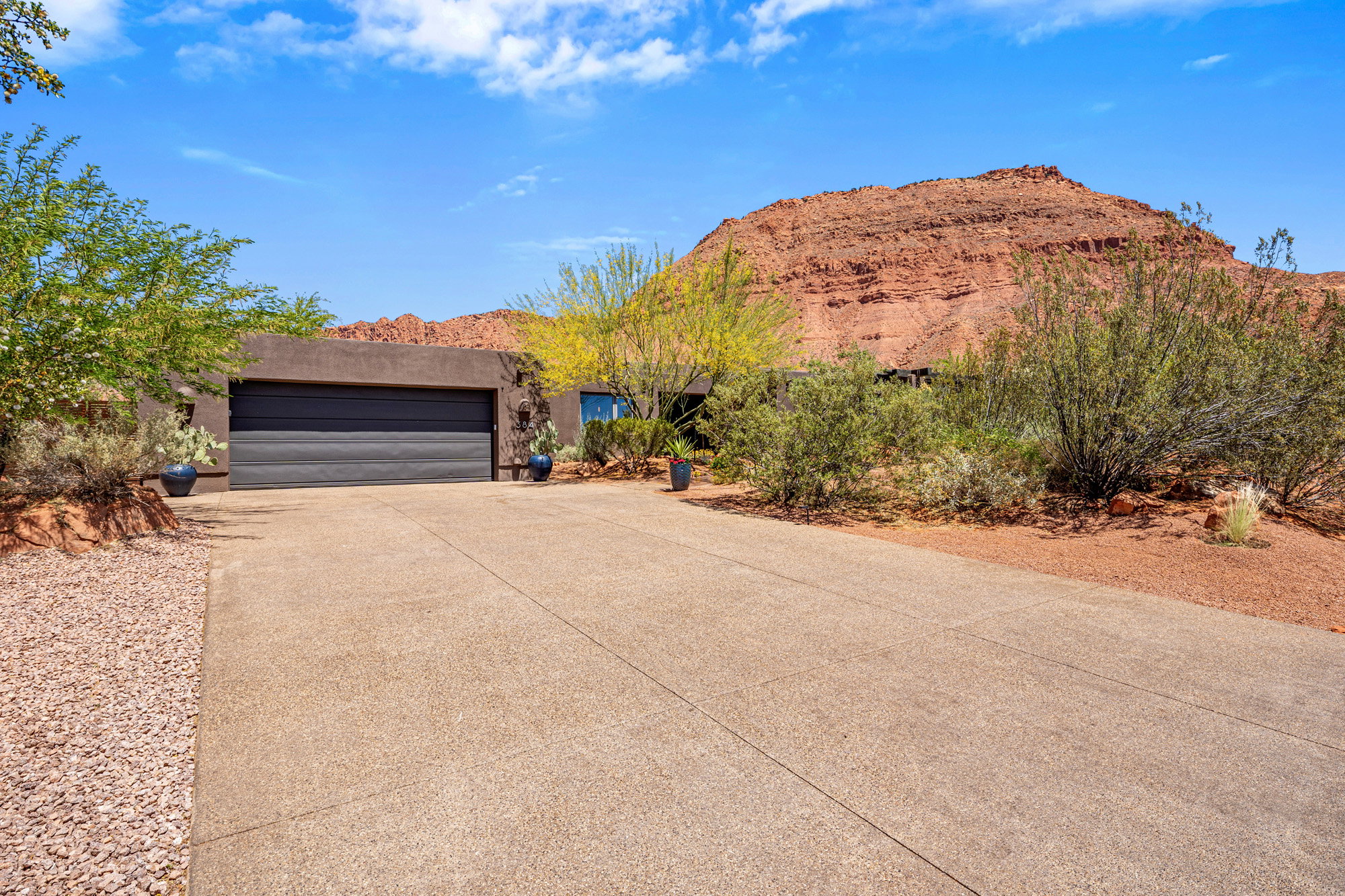 Single-story residence featuring a dark garage door and a concrete driveway
