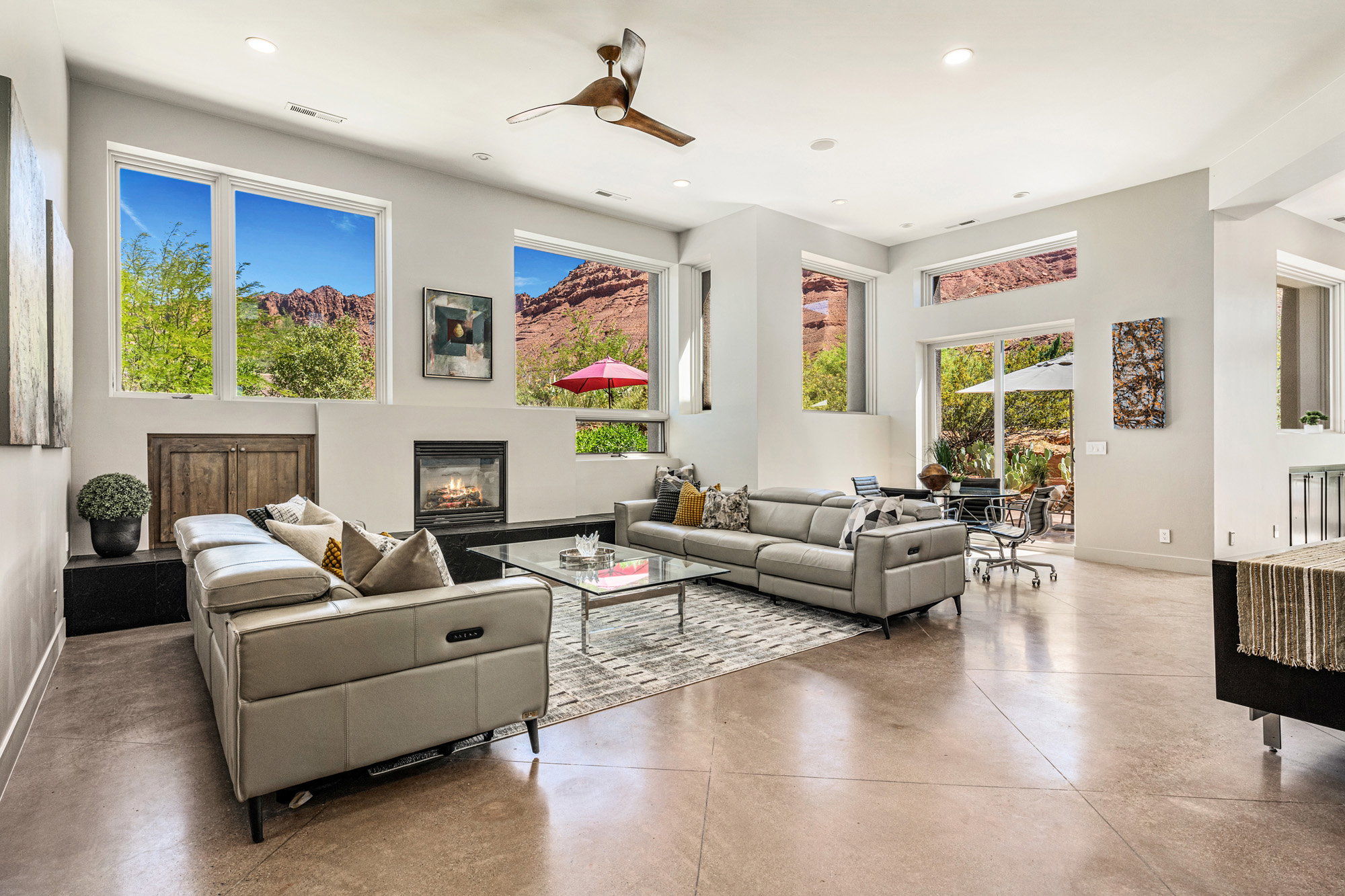Expansive open-concept living area featuring high ceilings, polished concrete flooring, and a contemporary fireplace
