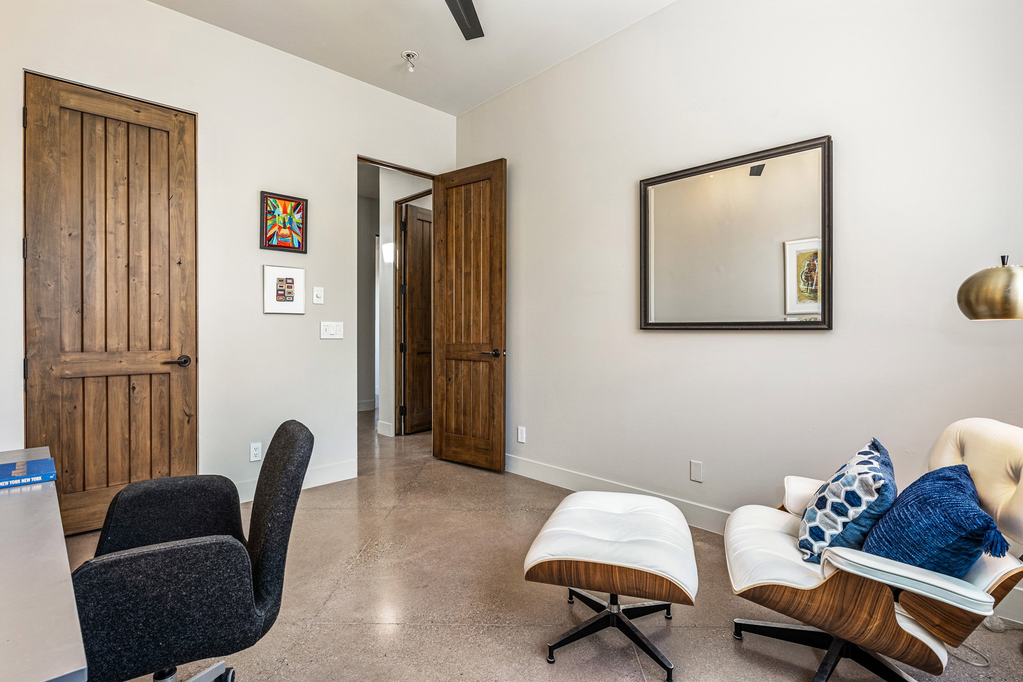 Interior space featuring polished concrete flooring, recessed lighting, and solid wood-paneled doors with dark hardware