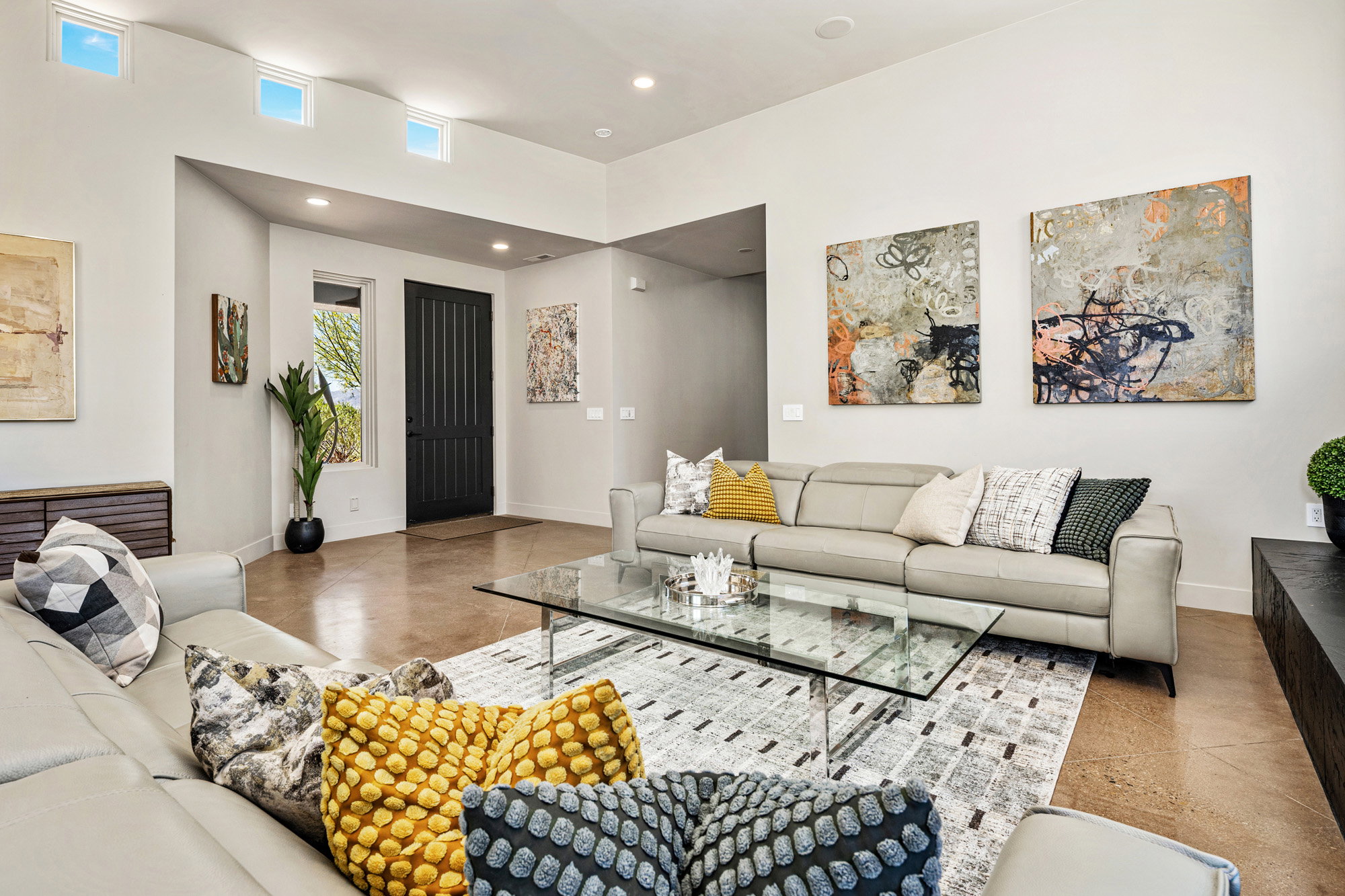 Open-concept living area with high ceilings, recessed lighting, and transom windows