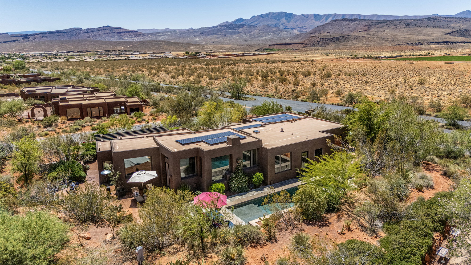 Contemporary flat-roof residence featuring an integrated swimming pool, exterior patio, and solar panels