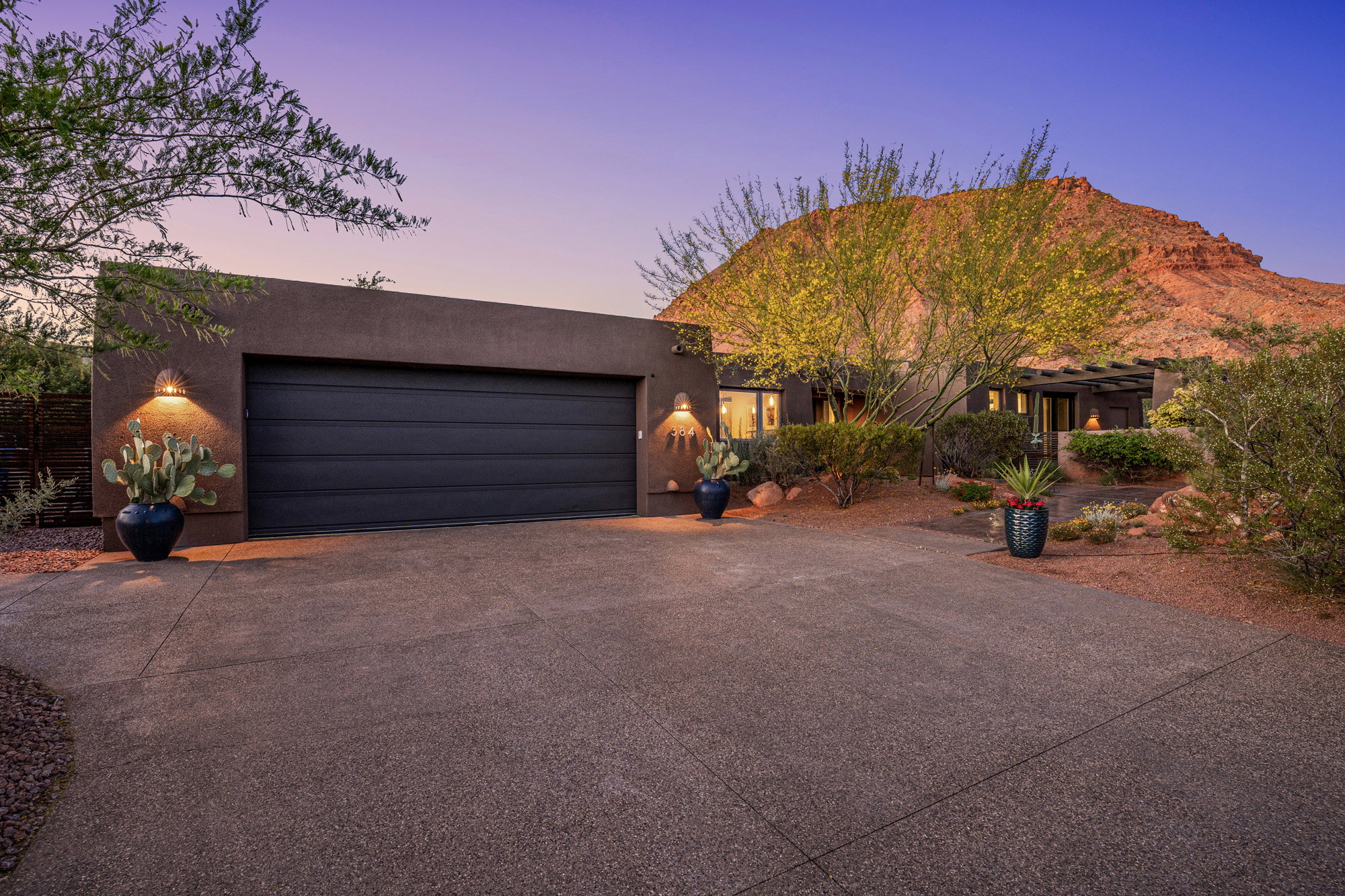 Stucco exterior with a two-car garage and integrated outdoor lighting