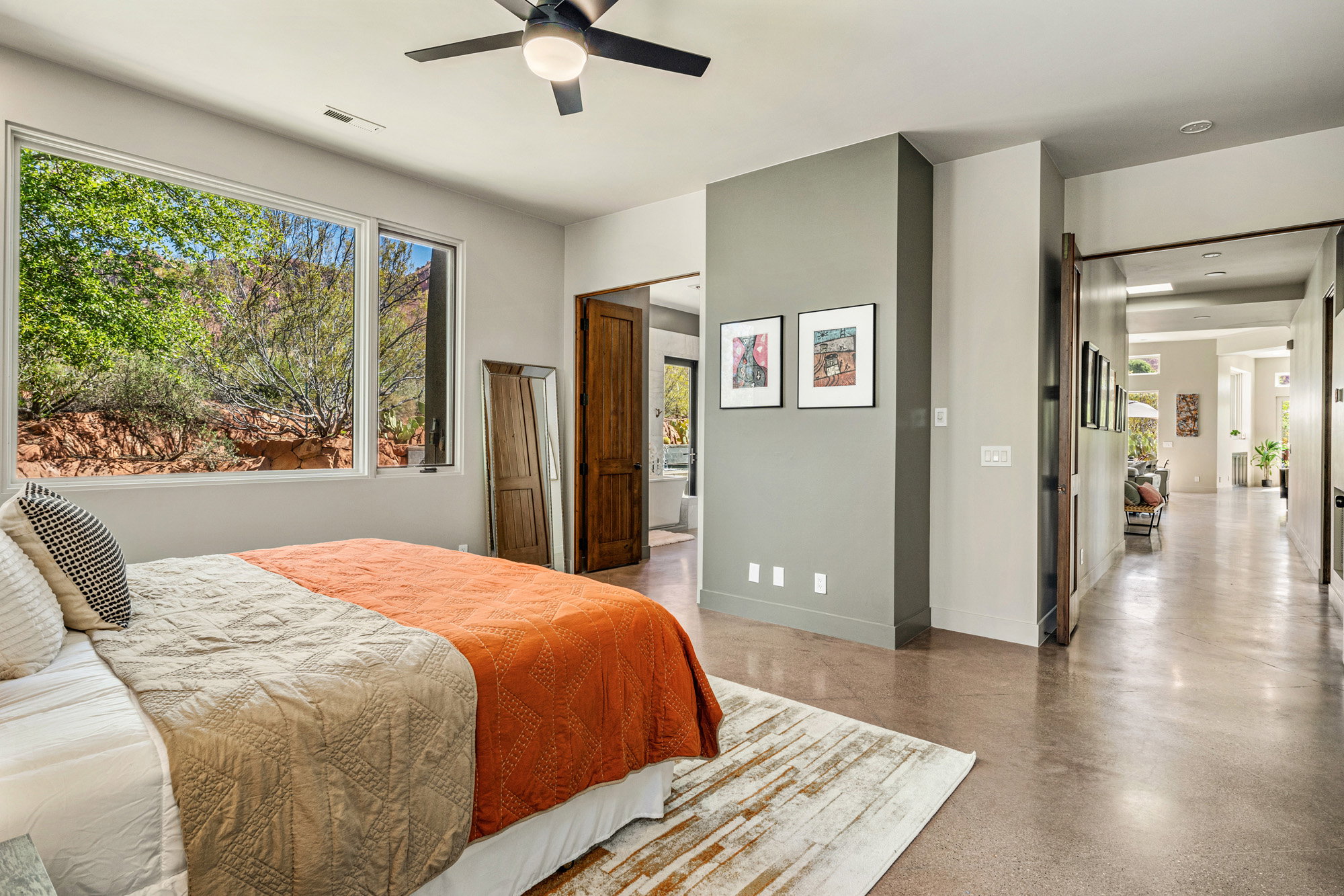 Room featuring expansive window, concrete flooring, and a ceiling fan
