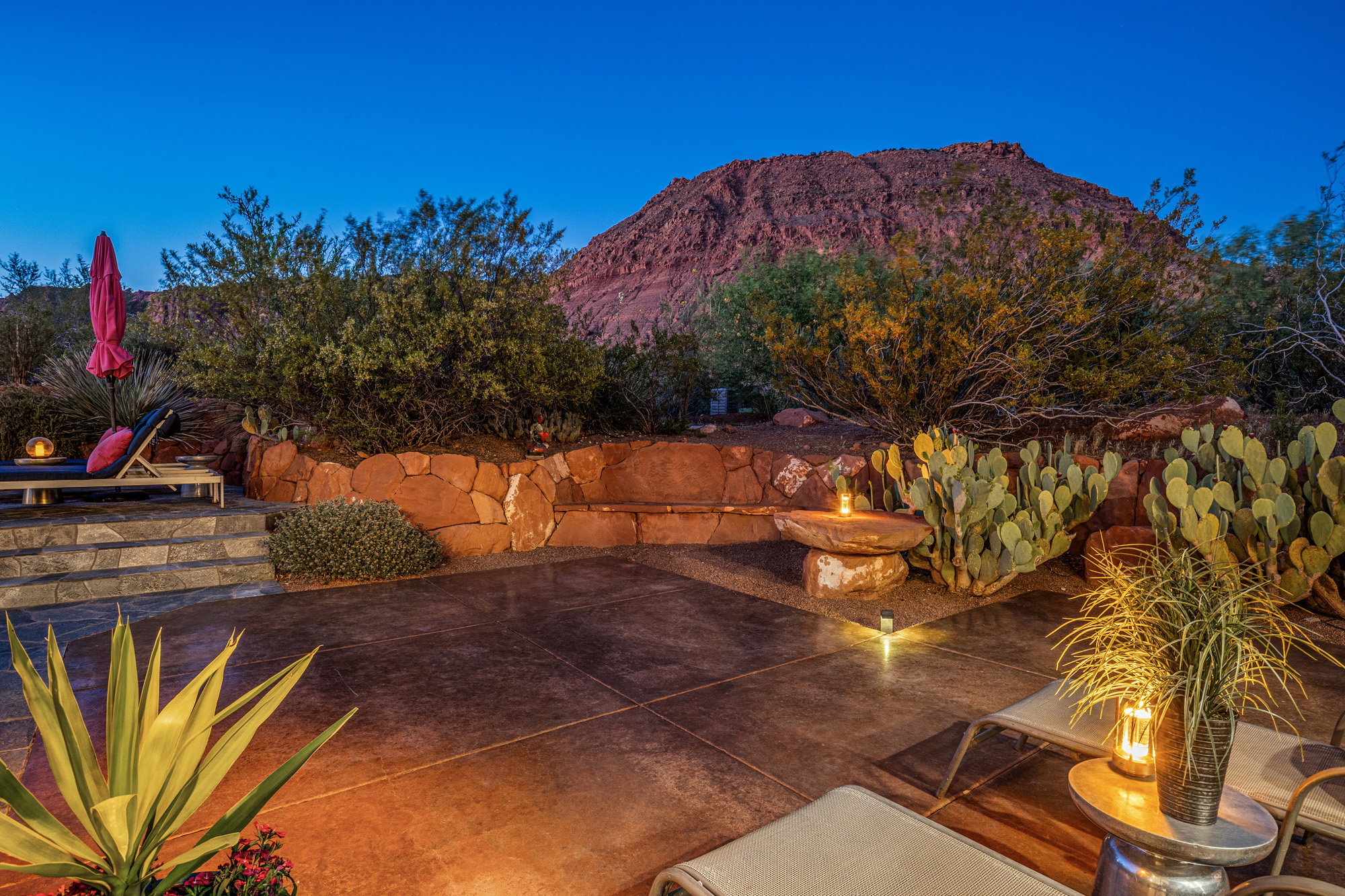 Expansive patio featuring a concrete surface, stone retaining wall, and desert landscaping