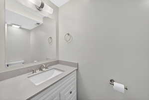 Contemporary vanity featuring a rectangular undermount sink, a light gray countertop, and brushed nickel fixtures