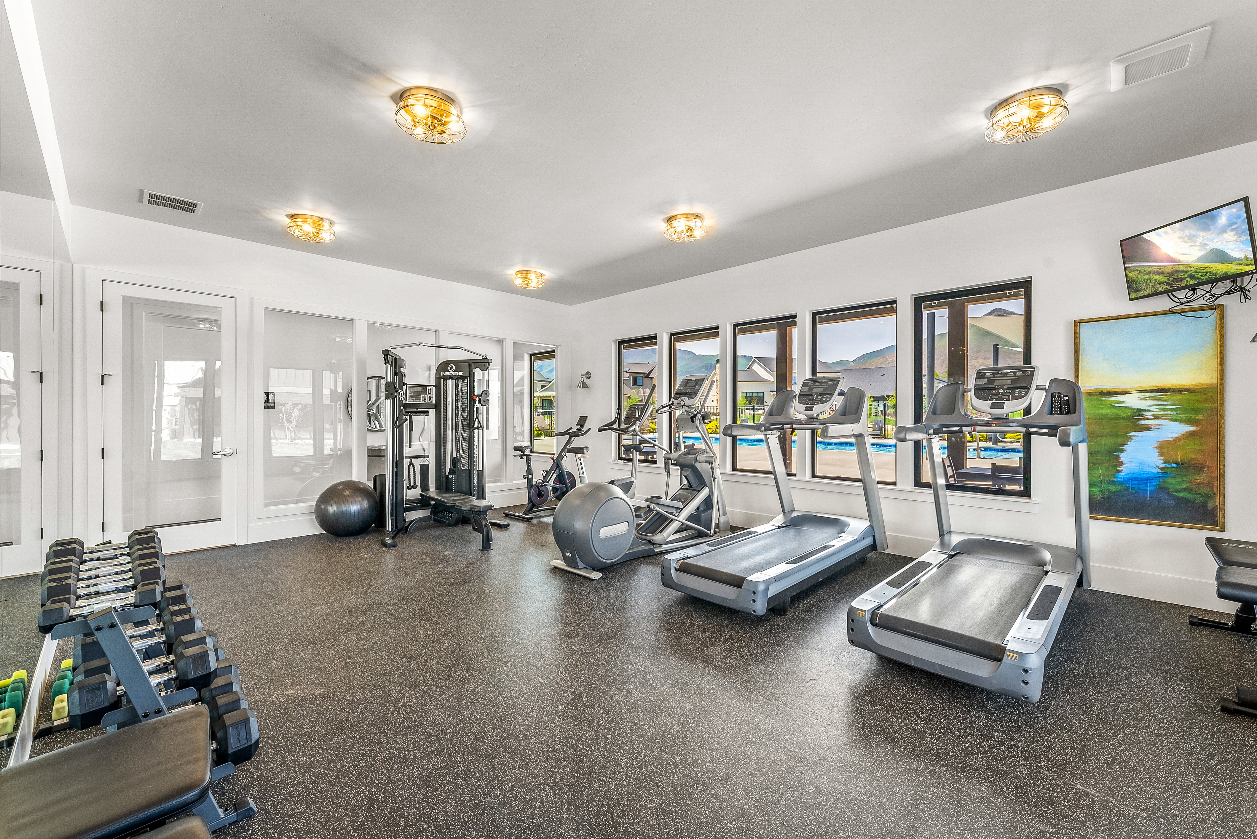Dedicated fitness center featuring rubber flooring and multiple windows
