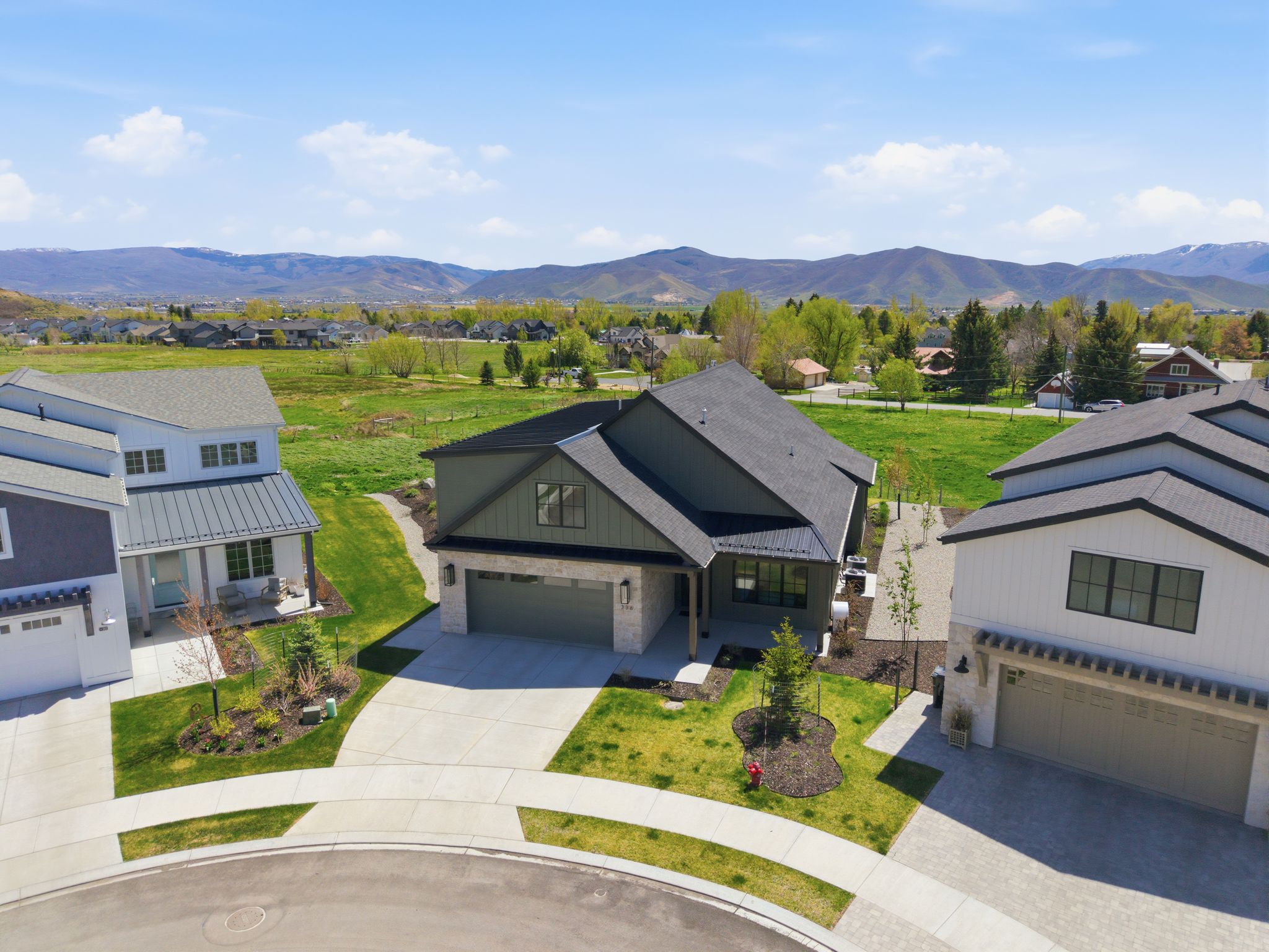Modern-style home featuring a dark gray exterior, attached two-car garage, and a concrete driveway