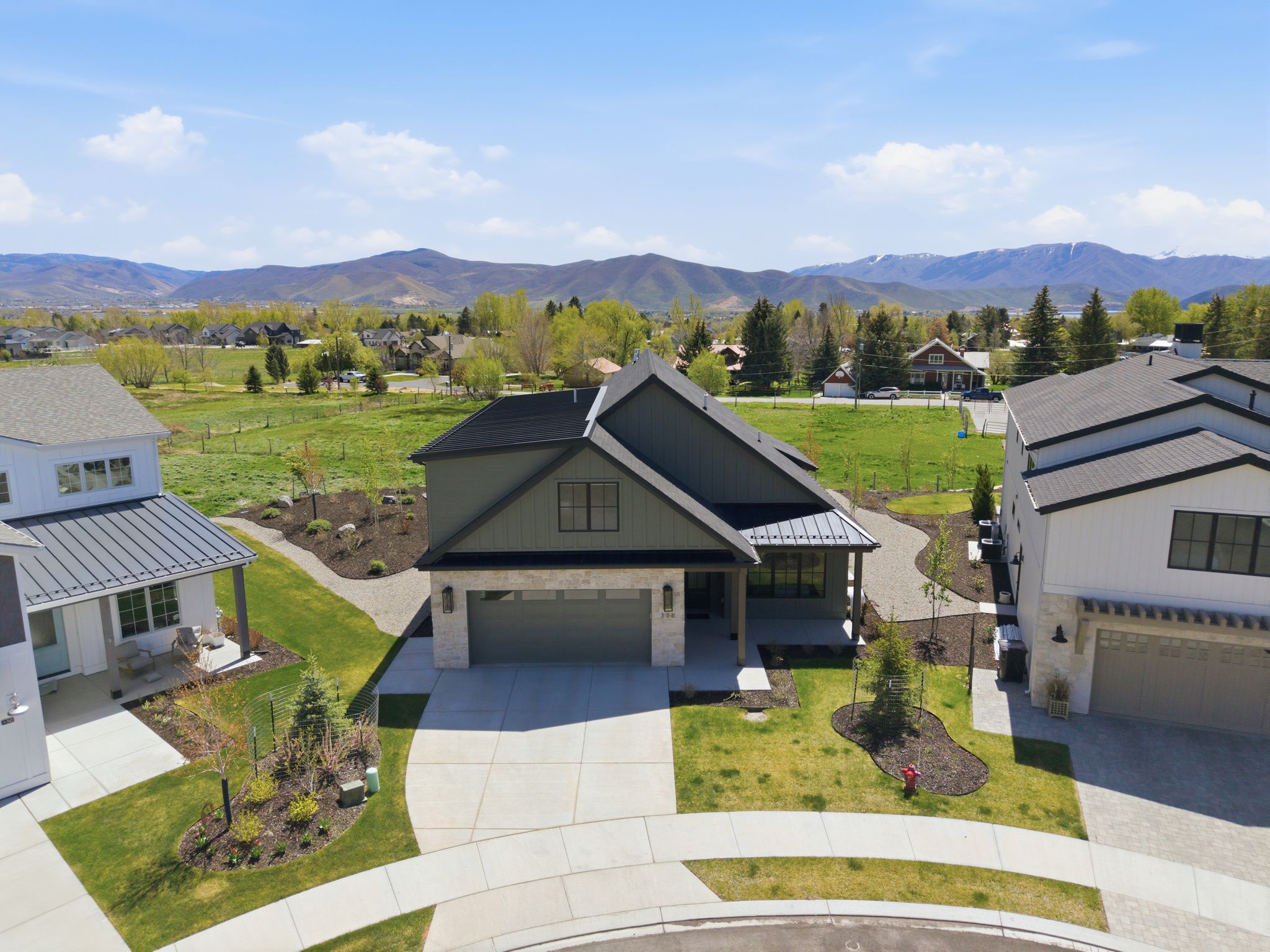 Modern residence featuring dark green board and batten siding with stone accents
