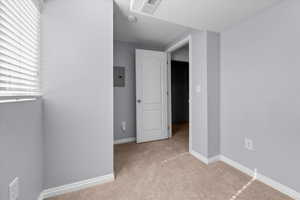 Carpeted room featuring light gray walls, white baseboards, and a window with horizontal blinds