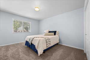 Bedroom featuring light blue walls, gray carpet, a white ceiling, and a single window with horizontal blinds
