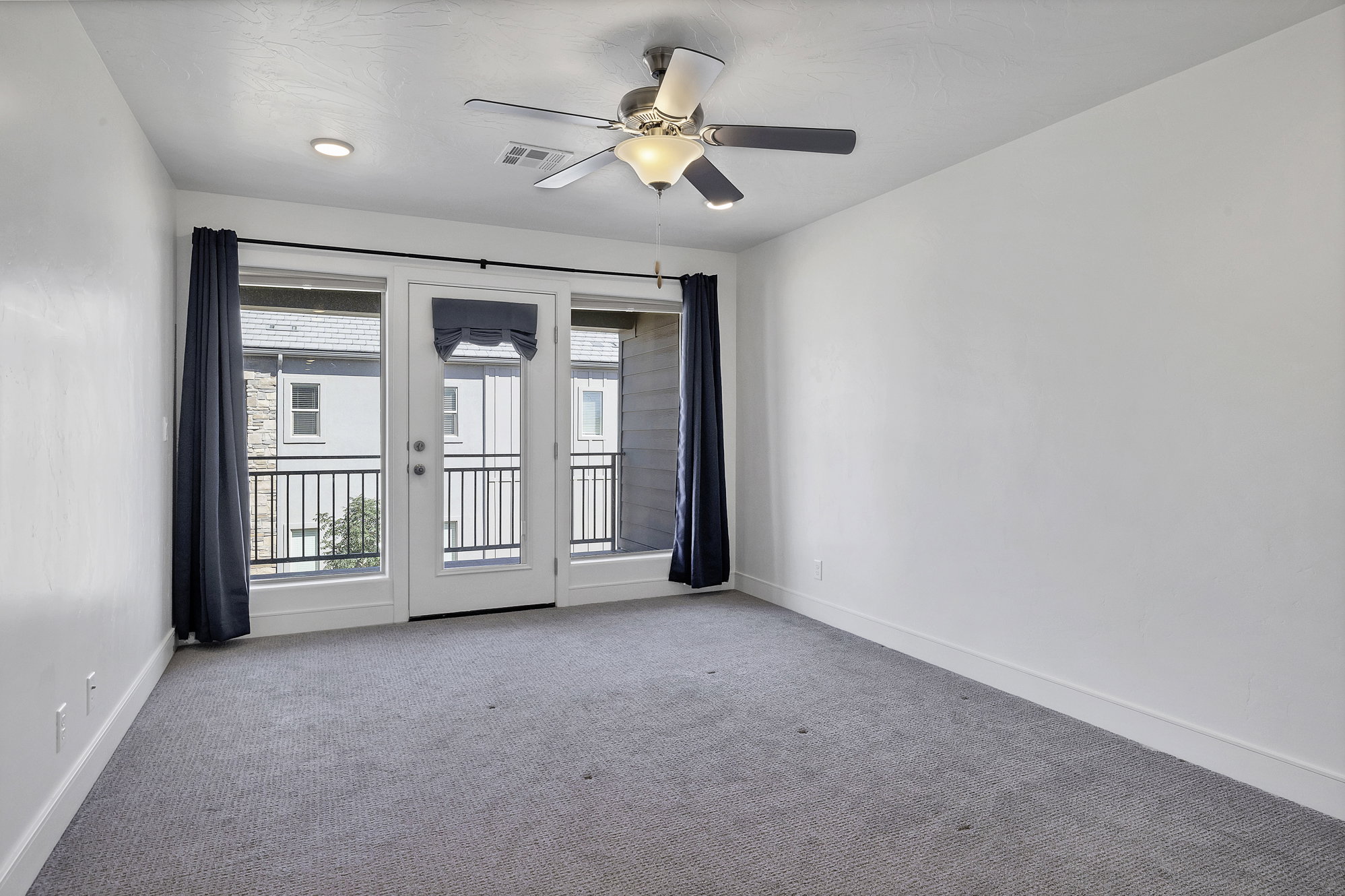 Bedroom with light gray carpeting and white walls