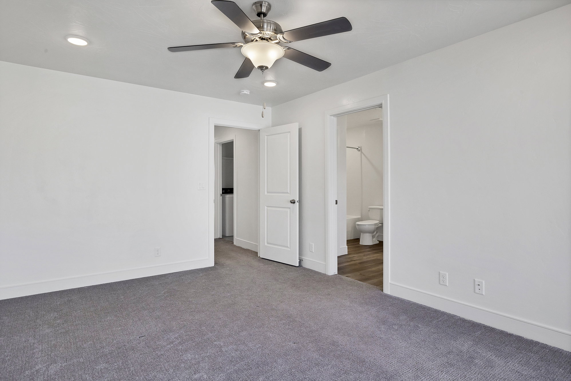 Bedroom featuring a ceiling fan with integrated lighting, recessed ceiling lights, and grey carpeting