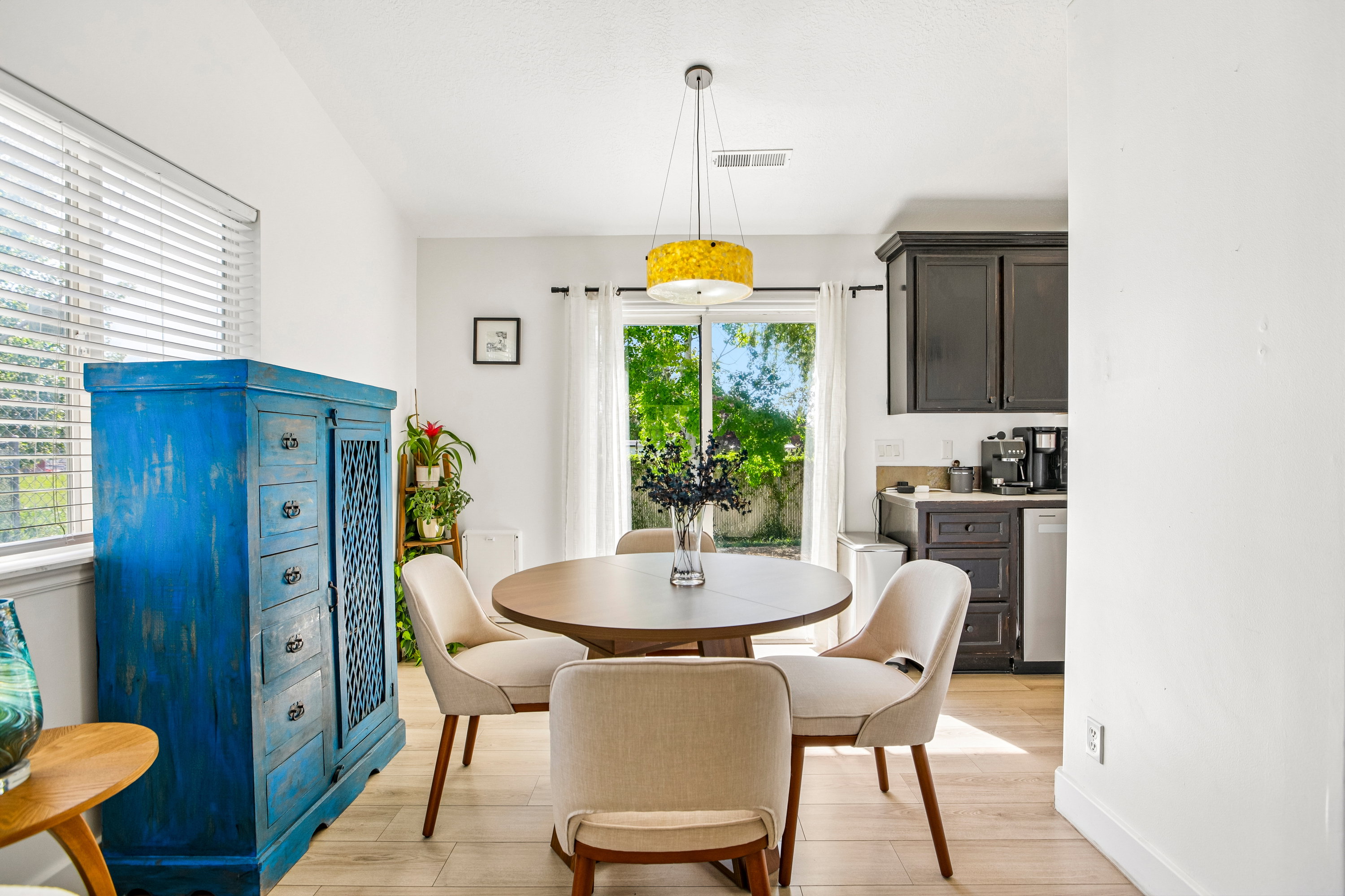 Dining area featuring light wood-finish flooring, a contemporary pendant light fixture, and a sliding glass door providing exterior access
