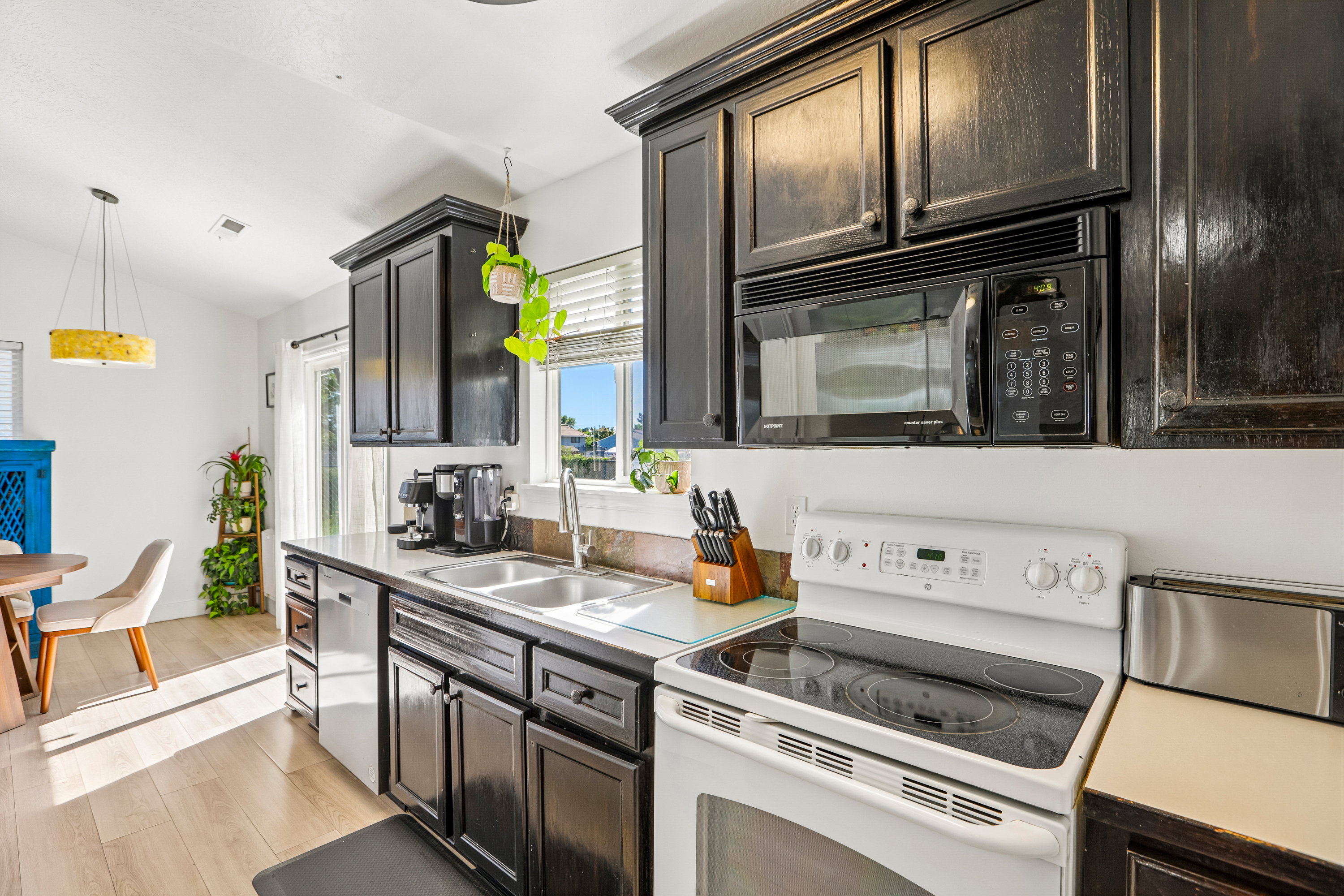 Kitchen with black cabinetry, a double basin sink, and a stainless steel dishwasher