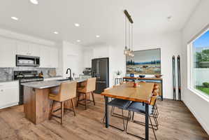 Open-concept kitchen and dining area featuring wood-finish flooring