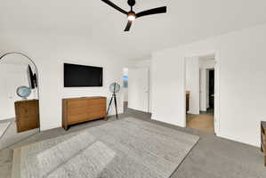 Spacious room featuring white walls, vaulted ceiling, and carpet flooring