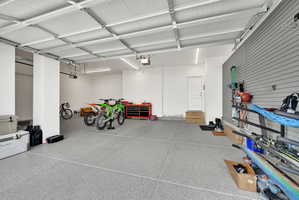 Spacious garage featuring an epoxy-coated concrete floor, white walls, and track lighting